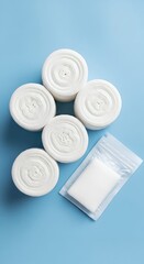 Top view of white round cotton pads for skincare arranged in a pattern on a blue background. Hygiene, makeup removal, and beauty cosmetic accessories.