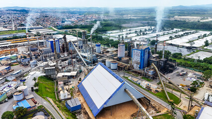 Imagem a&eacute;rea de f&aacute;brica de papel e celulose mostra caldeiras e chamin&eacute;s em opera&ccedil;&atilde;o, destacando produ&ccedil;&atilde;o cont&iacute;nua e gera&ccedil;&atilde;o de energia industrial.