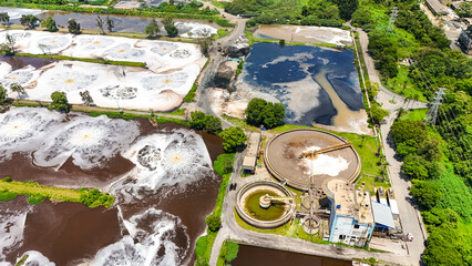 Fototapeta premium Visão aérea do sistema de tratamento de água e esgoto integrado a uma indústria de papel e celulose, mostrando tanques, tubulações e estruturas industriais voltadas ao controle ambiental e ao reaprove