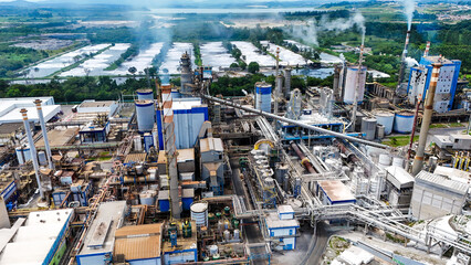Vis&atilde;o a&eacute;rea de planta industrial de papel e celulose com chamin&eacute;s e caldeiras, evidenciando produ&ccedil;&atilde;o em larga escala e infraestrutura fabril.