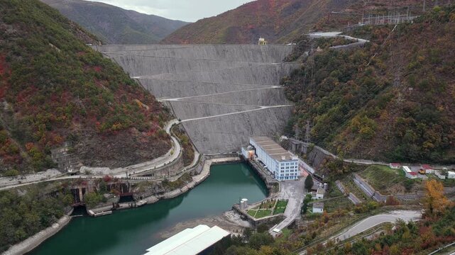 Aerial video of the Fierz&euml; dam and winding mountain roads surrounded by autumn hills.