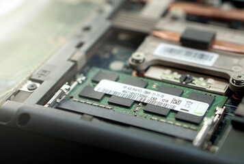 Close-up of a 4GB DDR3 RAM stick securely installed in a laptop. Offers a clear view of the silicon chips, product label, and motherboard circuitry.