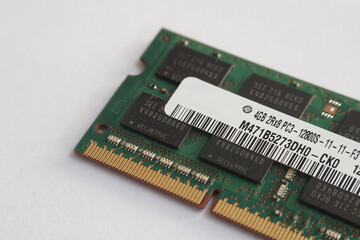 A 4GB DDR3 SODIMM RAM stick placed diagonally on a white surface. Shows the arrangement of memory chips and the gold connector interface.