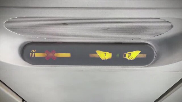 Airplane No Smoking Sign On and Seat Belt Sign Turning On Inside Aircraft Cabin - 4K