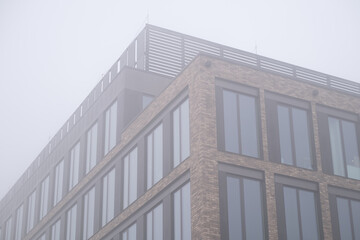 Fototapeta premium Modern apartment building facade in foggy urban environment