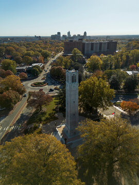Raleigh, NC - USA - 12-17-2025: The bell tower on the campus of NC State University in Raleigh NC along Hillsborough St, with city skyline in the distance