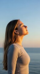 Obraz premium Woman Enjoying Sunset Ocean Breeze