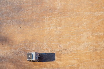 Aerial view of rooftop air conditioning outdoor unit casting shadow on textured surface, highlighting HVAC system installation and building services industry