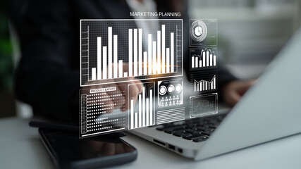 A business professional engages in marketing planning through digital analysis, showcasing graphs...