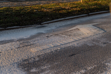 Urban roadway detail showing speed hump with faded road paint and asphalt texture, illustrating traffic calming infrastructure and street safety design