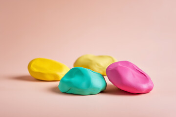 Colorful clay dough pieces on pink surface