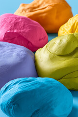 Vibrant multicolored clay balls on a blue background closeup