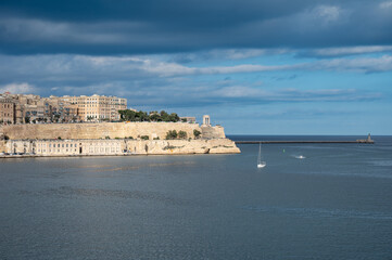 Obraz premium View of Valletta and Birgu with Fort St. Angelo prominently visible from Grand Harbour, Malta, showcasing historic coastal defense and Mediterranean cityscape Valletta, Malta, 6 DEC 2025.