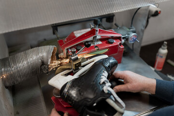 Automatic hockey skate blade sharpening process with sparks and precision clamping system, representing professional team level equipment maintenance operations