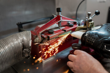 Automatic hockey skate sharpening process with sparks as equipment manager services blades, focused on professional team maintenance and ice hockey industry