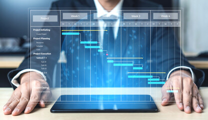 A businessman focused on analyzing a Gantt chart displayed on a tablet, representing project progress in a modern office setting, essential for effective planning. Tessel