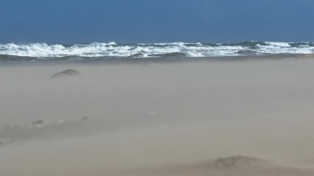 Strong Beach Wind Blowing Sand While Waves Crash in the Distance