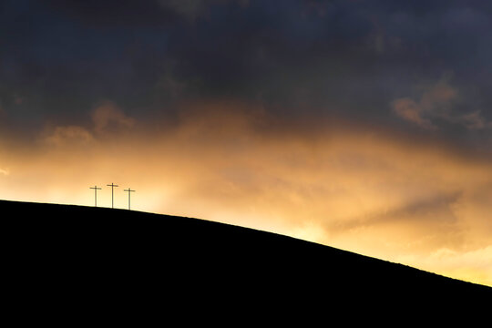 silhouette of three crosses on a hill at sunset - Powered by Adobe