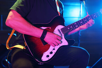 Man playing electric guitar on stage, closeup