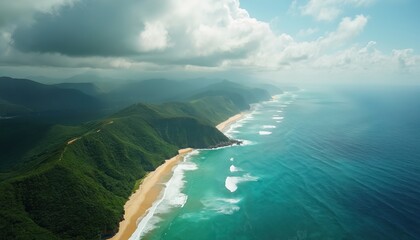 Aerial view of rugged green mountains meeting sandy beach and turquoise sea waves. Dramatic clouds form over peaceful coastal landscape. Ocean meets land on sunny day.