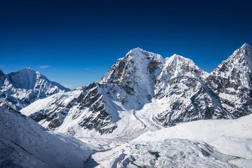 Helicopter flight over the huge Khumbu valley with Tabuche and Cholatse peaks on the horizon. Everest base camp trek, Himalaya mountains, Nepal. © Anna