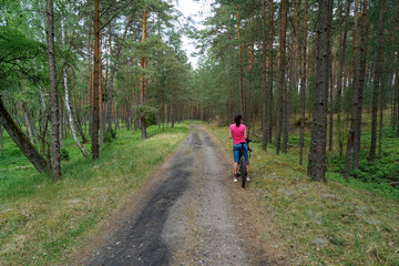 Obraz premium Kobieta w lesie na rowerze