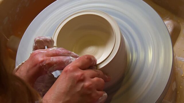 Top View of Potter Hands Shaping Clay on a Spinning Wheel