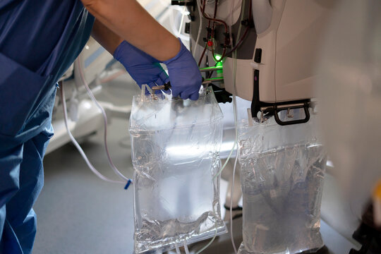 Nurse connecting dialysis solution bags to medical equipment