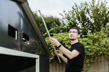 One young worker installs protective roofing corners on a metal barn.