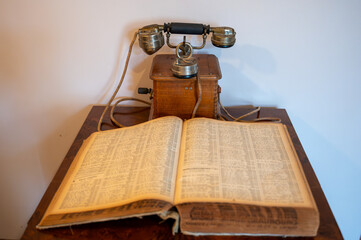 Communication progress, old wooden French rotary dial telephone and phone numbers catalog book from Paris, 1937