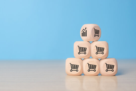pyramid of wooden cubes with sales icons. Sale volume increase make business grow, cube with icon graph and shopping cart symbol. growth of sales concept
