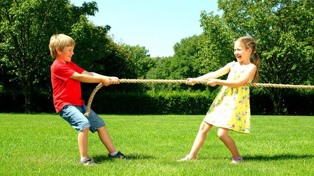 Two Children Tug of War Outdoors in Green Park.