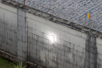 Muro de condom&iacute;nio residenical desgastado com o tempo e ilumina&ccedil;&atilde;o na parede