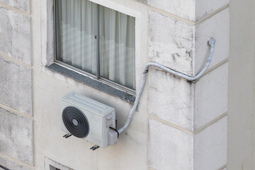 Unidade externa de ar-condicionado instalada em fachada de edif&iacute;cio residencial