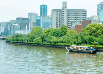 川を行く屋形船と都会のビル群、水上からの都市観光