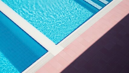 Abstract geometric composition of a swimming pool with blue water and colorful surrounding surfaces.