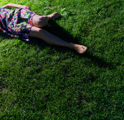 Leisure Outside: Woman in Colourful Dress Relaxing Barefoot on Green Lawn Under Sunshine, Vertical Shot Copyspace
