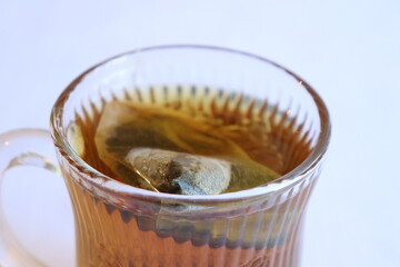 Close-up of cup of tea with a vintage glass. Green tea and hot drink in winter. Herbal tea with a withe background. Healthy drink and infusion. Tea break with green tea.