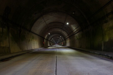 遠くまで真っ直ぐ続いている薄暗いトンネル
