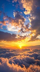 Fototapeta premium A vibrant sunset sky glows with orange and yellow hues above a sea of fluffy white clouds