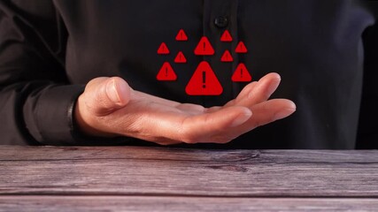 Close-up of a woman's hand on a table holding an animation of various warning signs.