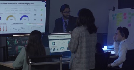 A focused team wearing headsets monitors live analytics dashboards and collaborates in modern control room. Highlighting customer support, data driven decision making, coordinated incident response.
- Powered by Adobe