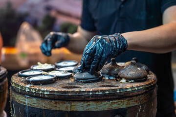 The chef's hands are preparing Banh Can. This is a popular dish that you can find in every corner of the country. People eat it for breakfast, lunch, and even dinner.
