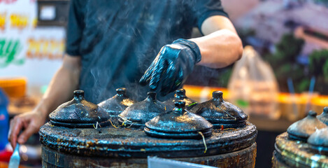 The chef's hands are preparing Banh Can. This is a popular dish that you can find in every corner of the country. People eat it for breakfast, lunch, and even dinner.