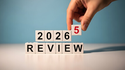 Hand placing a tile with the number five on a 2026 review board