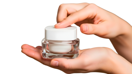 Close up of a person's hands holding and applying cream from a clear jar with a white lid