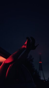 Urban nightlife aesthetic captured with confident model on flashy convertible under vibrant neon illumination