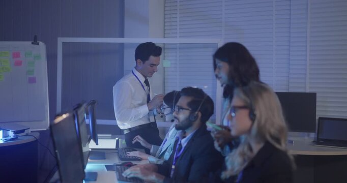A focused team wearing headsets monitors live analytics dashboards and collaborates in modern control room. Highlighting customer support, data driven decision making, coordinated incident response.
