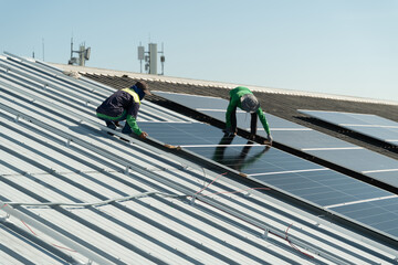 Workers install solar panels on a roof in a sunny location during the day for renewable energy generation