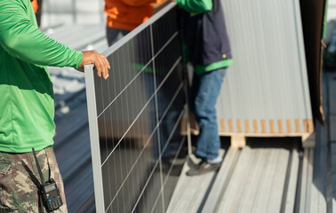 Workers install solar panels on a roof in a construction project during daytime in a sunny location